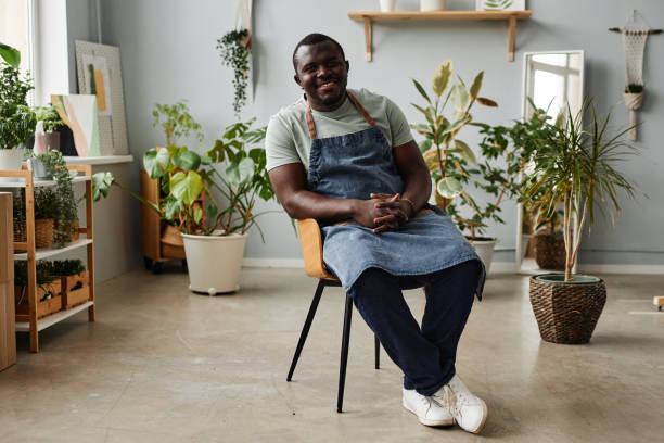 istock Black man as gardener wearing apron and posing indoors looking at camera 1480122919