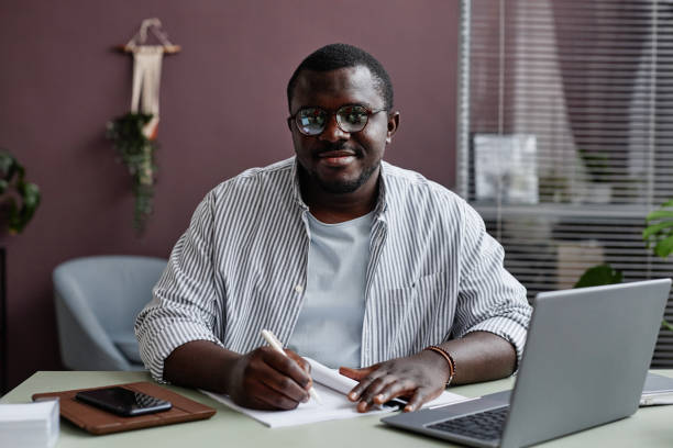 istock Smiling black man wearing glasses at workplace in office 1480122981