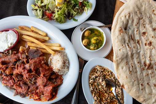 Plate of Iskender or Bursa Kebab with a Turkish mezze and traditional bread. Typical local cuisine in Turkey