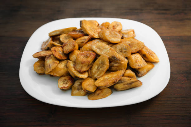 istock Tasty deep fried banana slices on wooden table 1480126056