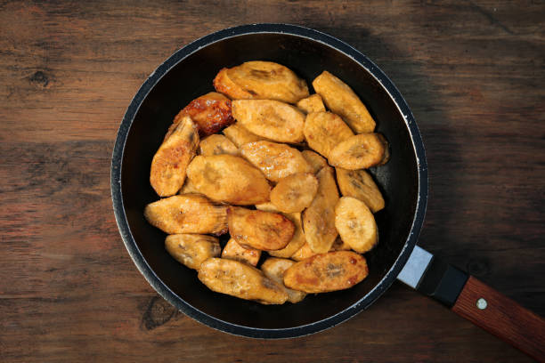 istock Tasty deep fried banana slices on wooden table, top view 1480126077