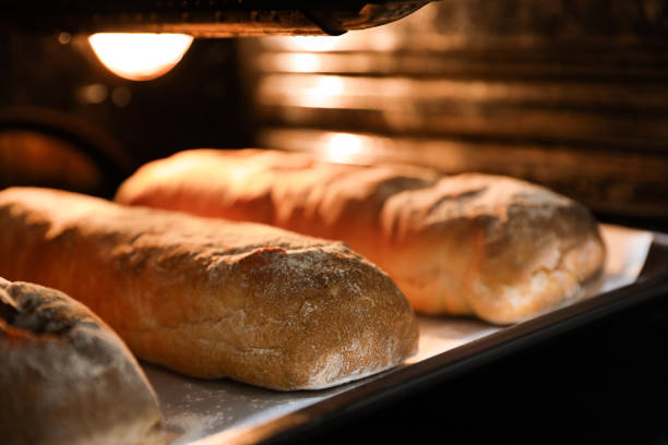 cocinar ciabattas crujientes frescas en horno, primer plano - ciabatta fotografías e imágenes de stock