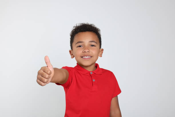 istock African-American boy showing thumb up on light grey background 1480126997