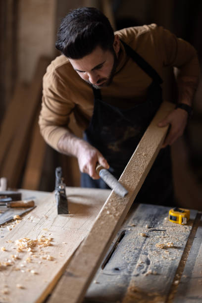 istock Young carpenter using sander while working on a piece of wood. 1480127390