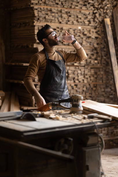 istock Young carpenter using sander while working on a piece of wood. 1480127537