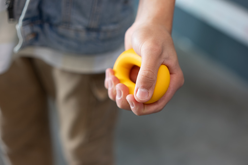Young boy exercising holding a rubber expander.