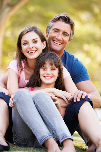istock Family Sitting On Grass In Summer Park 148013712