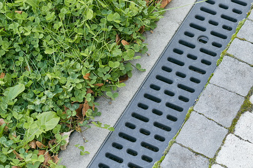 Technologies for rainwater drainage on the street. Stormwater cast iron drainage system in a pavement. Is used for drainage and separation of water from footpath