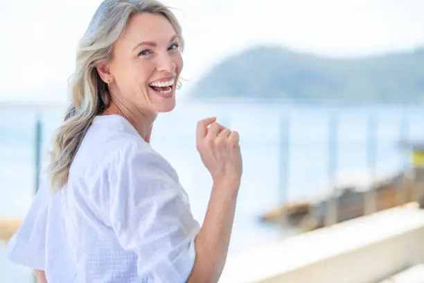 Photo of Beautiful mature woman portrait at waterfront house.