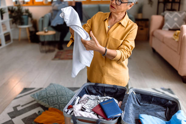 istock Senior woman packing suitcase, preparing for vacation trip 1480152605
