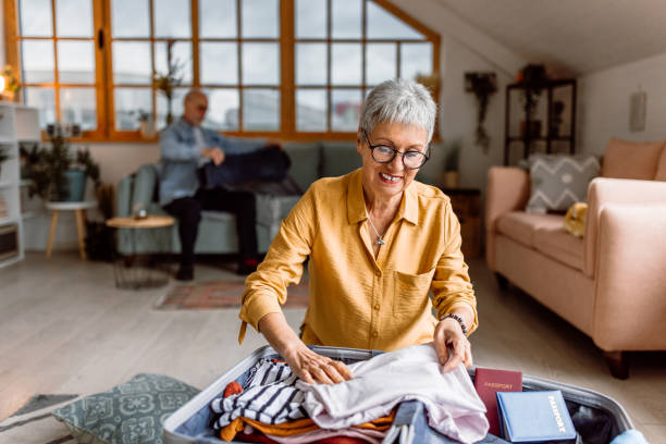 istock Senior woman packing suitcase, preparing for vacation trip 1480152608