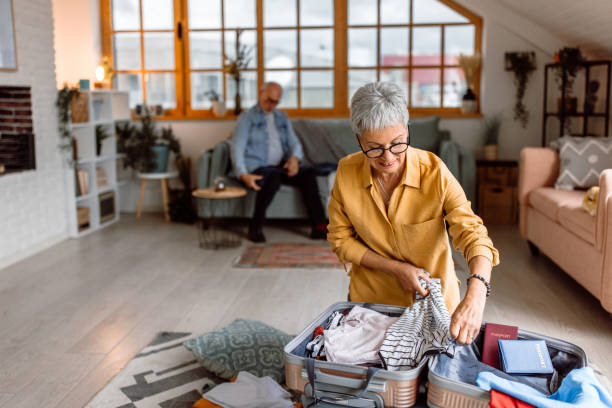 istock Senior woman packing suitcase, preparing for vacation trip 1480152644