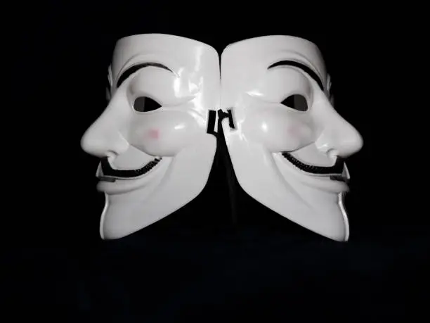 Two Guy Fawkes masks lying back to back.