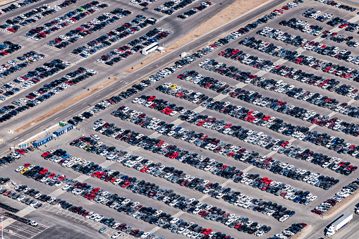 Aerial view of a parking lot crowded with employee vehicles at the new manufacturing corporation in Austin, Texas.