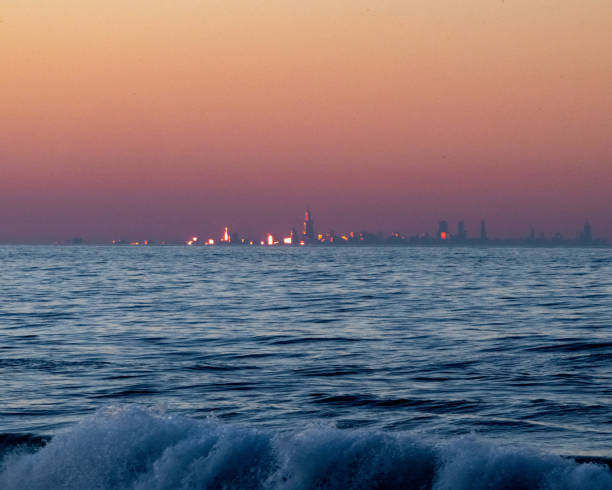 sunset reflected on the chicago skyline across lake michigan - chicago lake michigan skyline indiana imagens e fotografias de stock