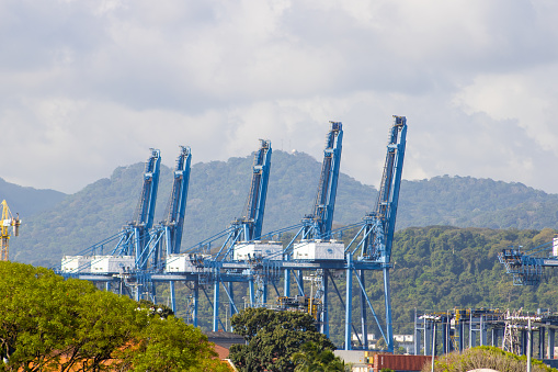 Panama City, Panama - Decemeber 28,2022: Lateral view of 5 harbor crane used to move containers from ships to trains, station near Panama Canal.