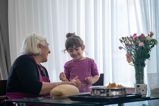 Shot of happy family grandmother and granddaughter making chocolate cake in the kitchen