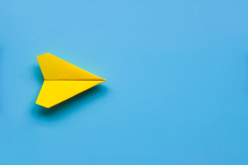 Top view of single yellow paper airplane with customizable space for text. Copy space.