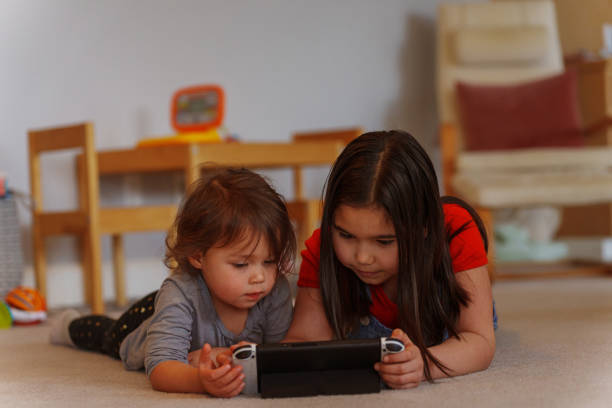 istock Sisters having fun playing video games together 1480169376