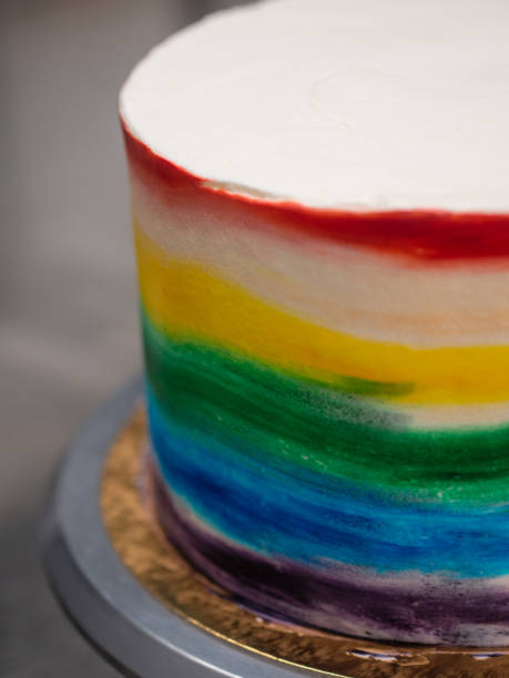 istock chef pastry baker making a frosted cup cake with rainbow colors - lgbt pride celebration anniversary 1480177306