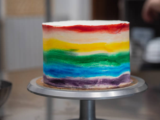 istock chef pastry baker making a frosted cup cake with rainbow colors - lgbt pride celebration anniversary 1480177395