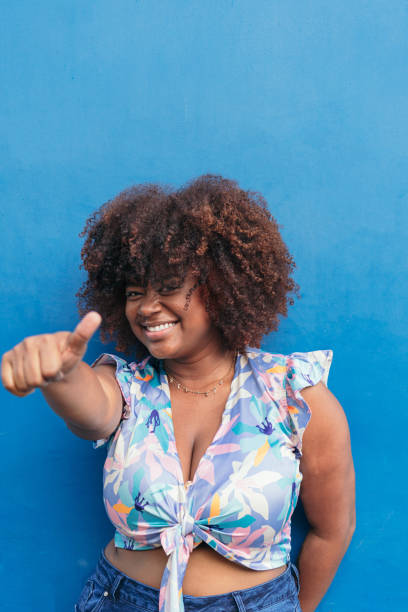 istock young African girl smiling with blue background. 1480177984