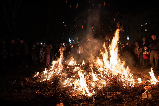 People burning Badnjak on Orthodox christmas night in belgrade, Serbia. The badnjak also called veseljak is a tree branch or entire tree that is central to Serbian Christmas celebrations. It is placed on a fire on Christmas Eve and its branches are later brought home by worshipers. The tree from which the badnjak is cut, preferably a young, straight and undamaged Austrian oak, is ceremonially felled early on the morning of Christmas Eve.
