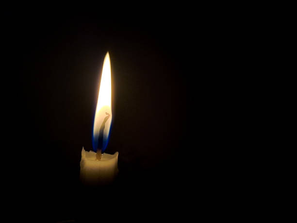 istock candle in the dark. One light candle burning brightly on a black background 1480182675