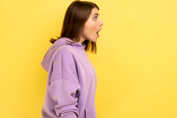 istock Dark haired woman looking with shocked expression to side, keeps mouth widely open. 1480182828