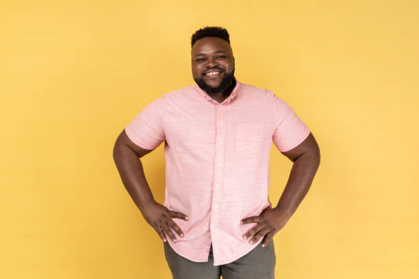 istock Man standing with hands on hips and looking at camera with toothy smile, expressing happiness. 1480183566
