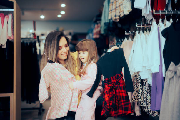 mother and daughter shopping for dresses - boutique shopping retail mother imagens e fotografias de stock