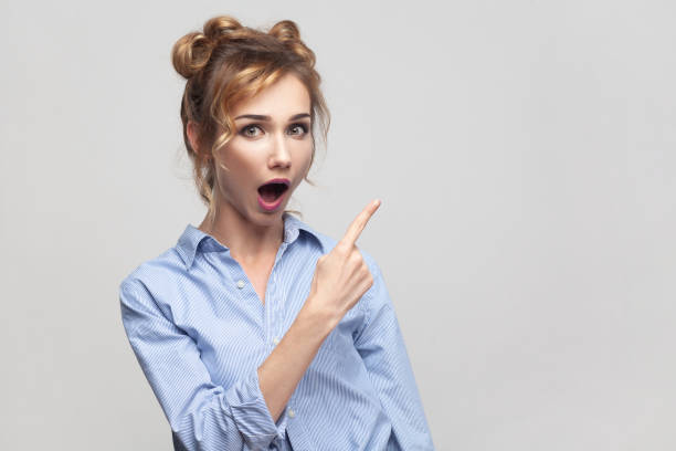 istock Woman pointing to side copy space with shock, demonstrates crazy advertisement grabs your attention. 1480184636