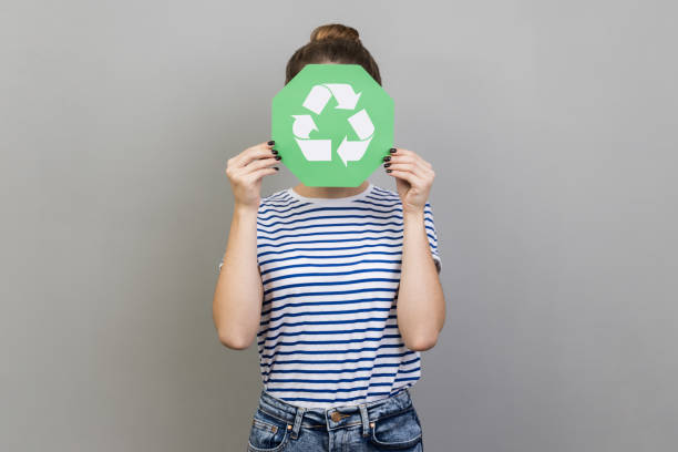 istock Unonymous woman covering her face with green recycling sign, environmental problems. 1480184671