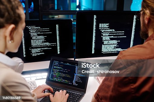 istock Close-up of two young developers working over data decoding software 1480186569