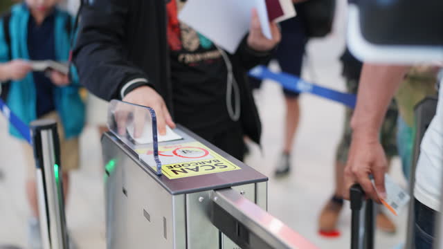 Checking your travel history with modern technology makes traveling safe. Close up hand of passenger scanning boarding pass at the gate and look at the monitor before entrance to the security check up. Travel aboard during holiday.