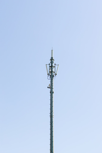 Close up to a 5G antenna with dish mounted high on the roof of a modern construction