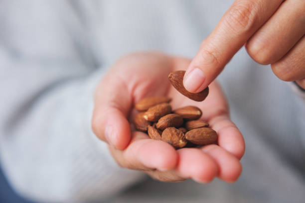istock Closeup image of hands holding and picking up an almonds 1480208936