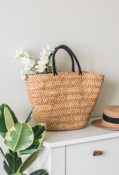 istock Wicker straw basket with a bouquet of flowers on a white table 1480220090