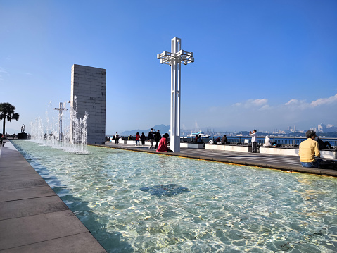 People relaxing by the fountain at Sun Yat Sen Memorial Park, a waterfront park in the Sai Ying Pun area of Hong Kong Island, facing Victoria Harbour. The park is named after Sun Yat Sen.