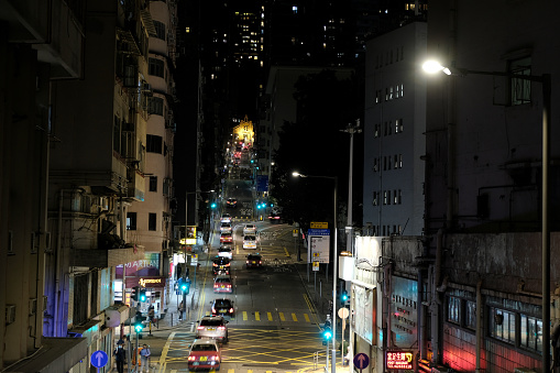Traffic on Western street in Sai Ying Pun residential area by night, Western District, in the northwestern part of Hong Kong Island.