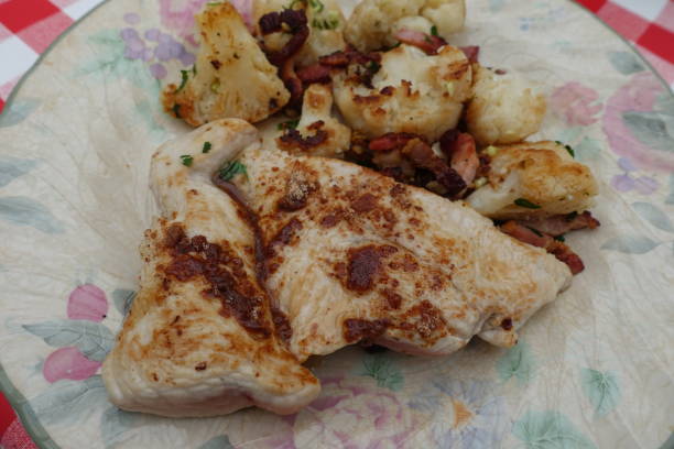 Turkey cutlet cooked with spices served with cauliflower and bacon bits
