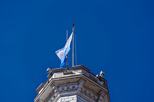 Blue and white flag of Canton Luzern and City of Luzern waving at luxury hotel Castle Gütsch on a sunny spring day. Photo taken March 22nd, 2023, Lucerne, Switzerland.