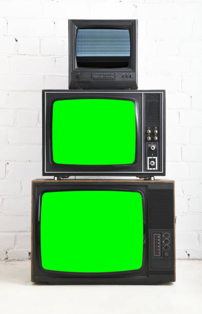 istock Three old televisions with a green screen against a white brick backdrop. 1480228017