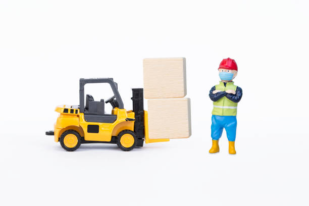Hispanic man, 40s, in warehouse driving forklift.