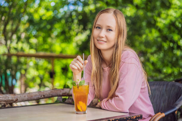 istock Eco friendly woman using reusable stainless steel straw to drink fruit tea 1480228353