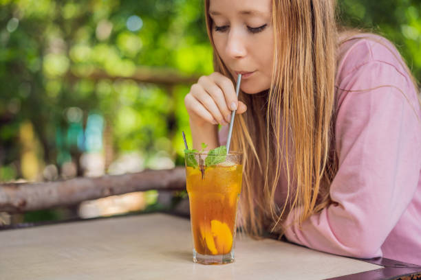istock Eco friendly woman using reusable stainless steel straw to drink fruit tea 1480228354