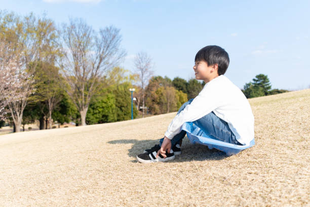 Smiling boy sitting on the grass in the park