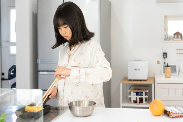 istock Elementary school girl in pajamas standing in the kitchen 1480230927