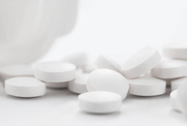 опиоидные обезболивающие, наркотические, закрывают белые таблетки флаконом. - medicine pill prescription medicine narcotic стоковые фото и изображения