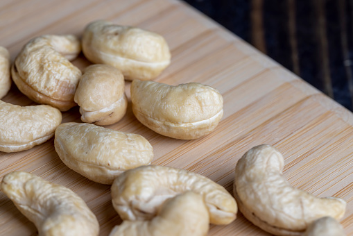 Hard roasted and peeled cashew nuts on the table, delicious cashew nuts on a wooden surface